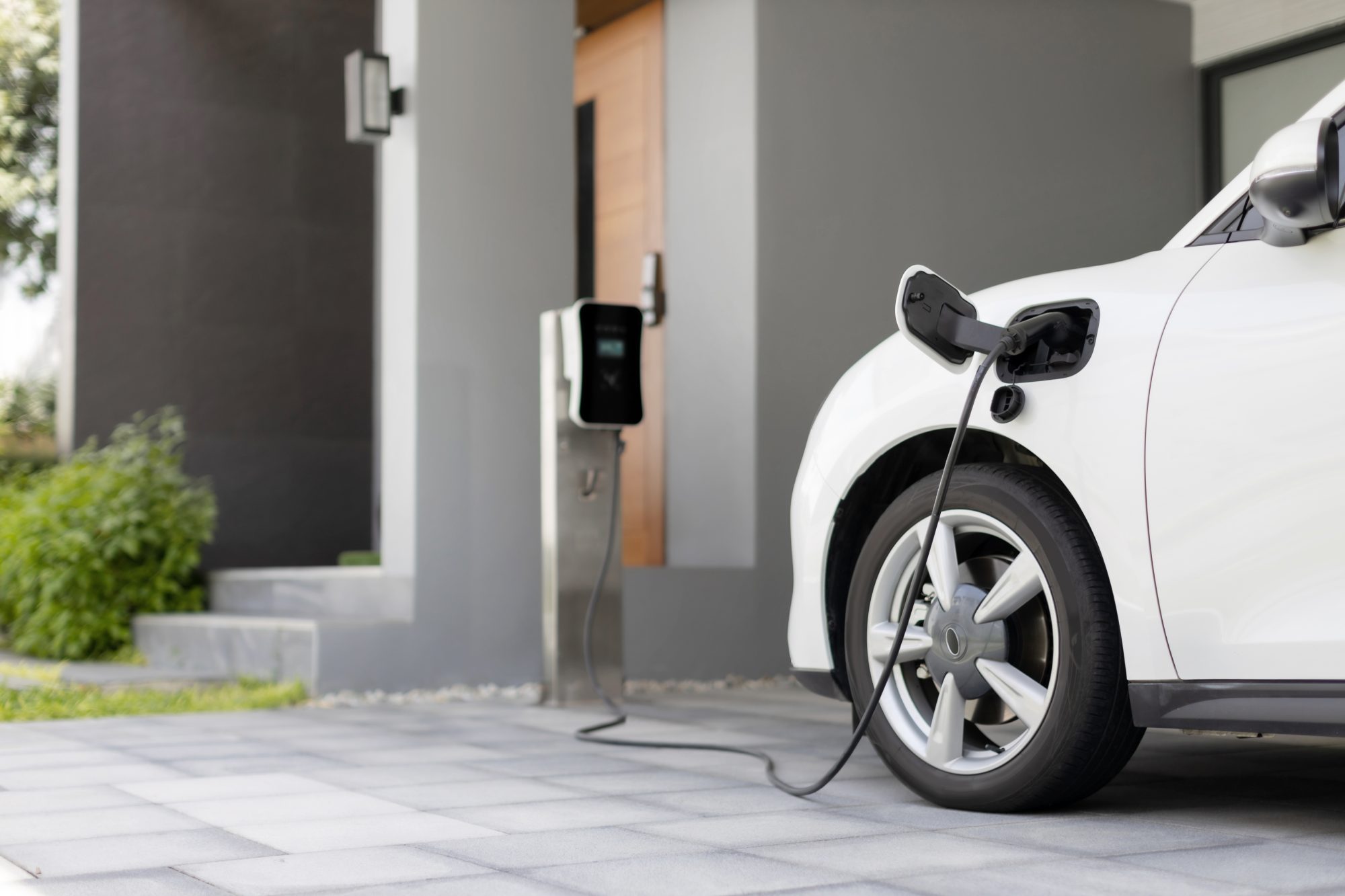 Progressive concept of EV car and home charging station powered by sustainable and clean energy with zero CO2 emission for green environmental. Charging point at residential area for electric vehicle.